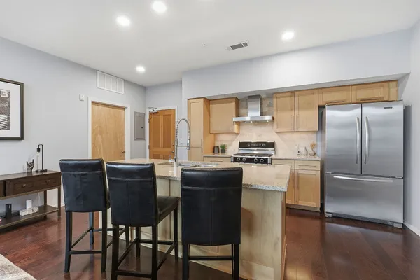 a kitchen with a table chairs refrigerator and cabinets