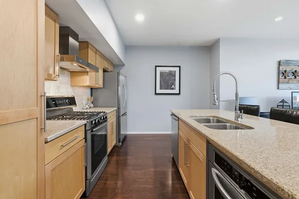 a kitchen with granite countertop a sink stove and cabinets