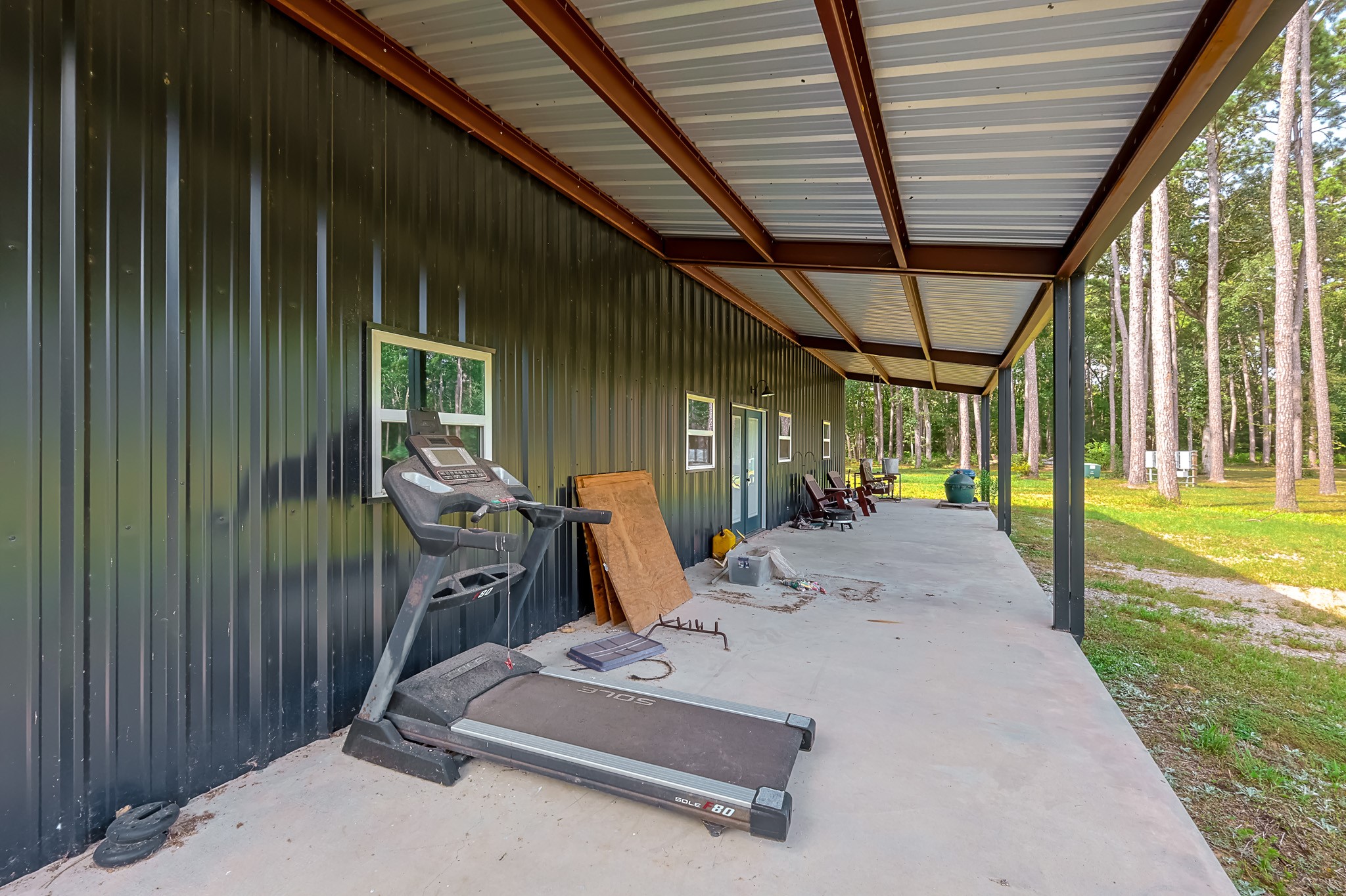 6409 Medley Road New Waverly, TX 77358 - Photo 42 of 50 A wide covered porch runs across the front of the shop. This shop has a double walk-thru door entry, windows on the front and large roll-up doors on 3 sides.
