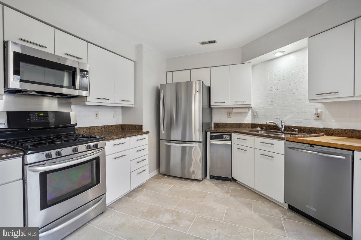3004 Courtside Road Bowie, MD 20721 - Photo 17 of 45 a kitchen with stainless steel appliances granite countertop a stove a refrigerator and a microwave