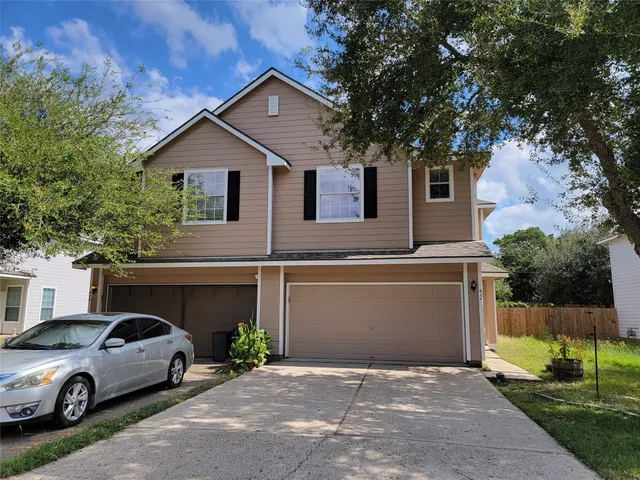 a front view of a house with parking space and a car parked