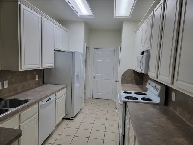 a kitchen with a sink appliances and cabinets
