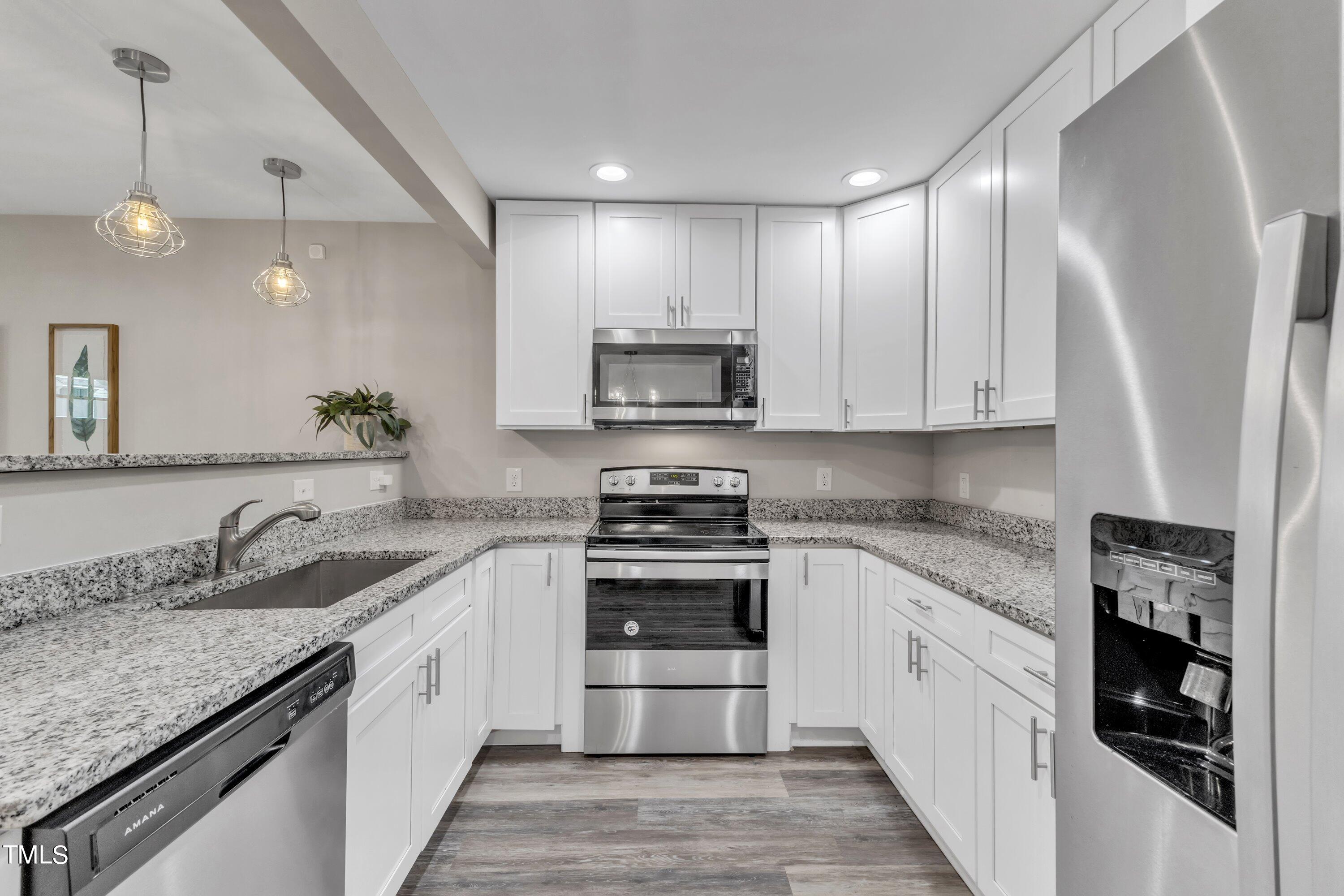 701 Coleman Street Raleigh, NC 27610 - Photo 13 of 38 a kitchen with stainless steel appliances granite countertop a stove and a sink