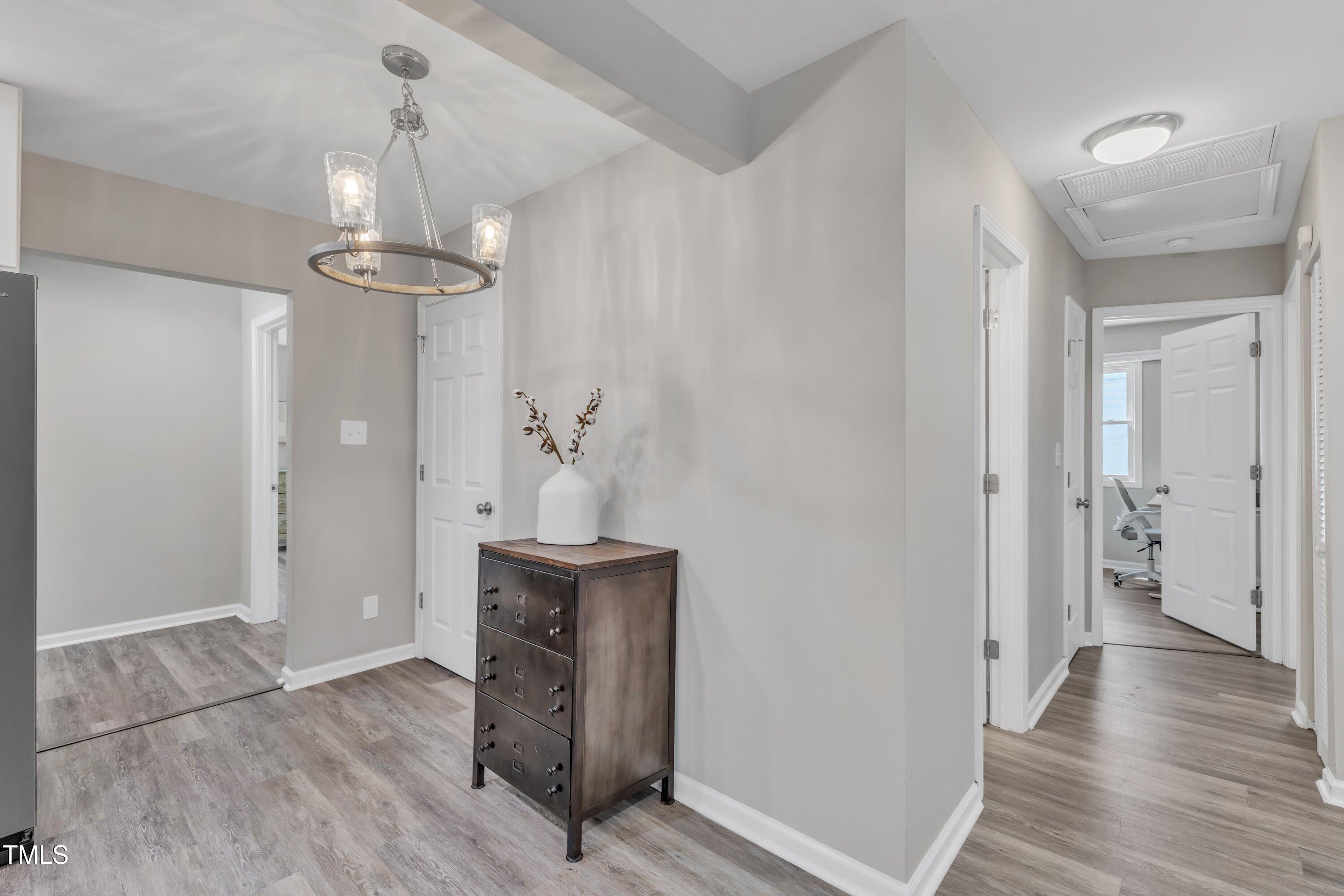 701 Coleman Street Raleigh, NC 27610 - Photo 17 of 38 a view of hallway with chandelier and wooden floor