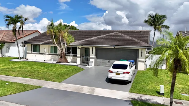 a car parked in front of a house with a garden