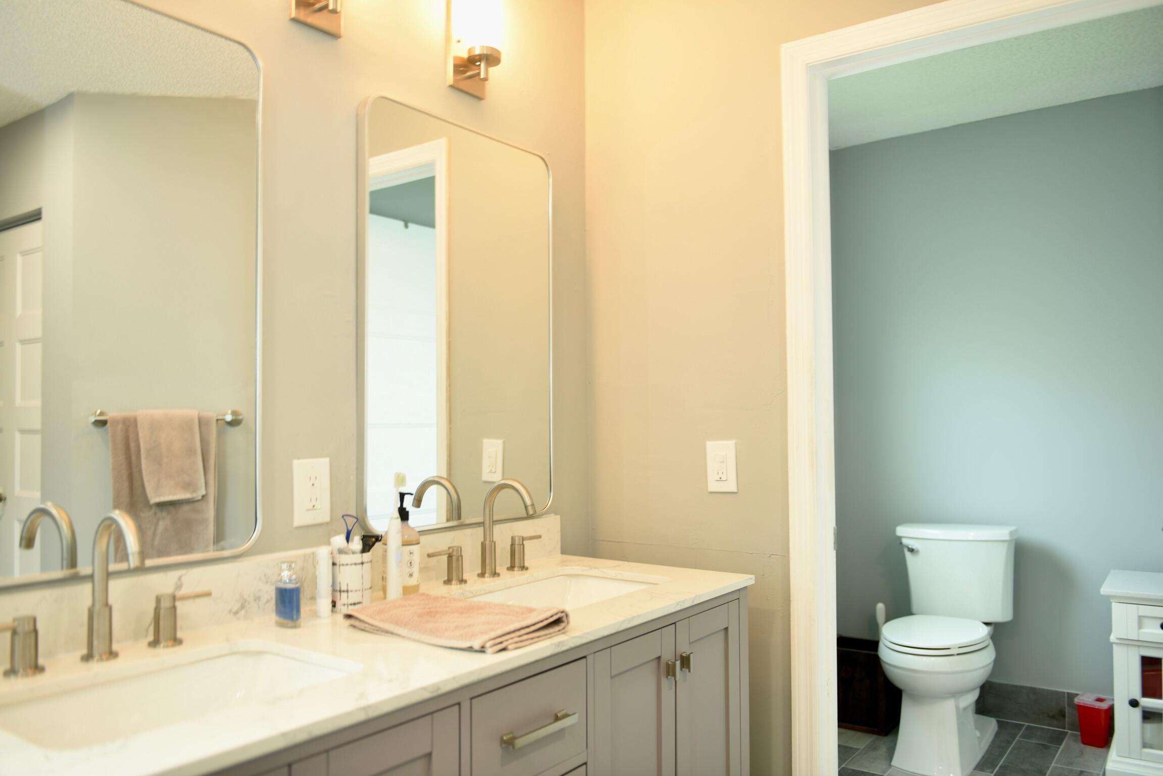 14931 Southwest 168th Court Miami, FL 33187 - Photo 13 of 34 a bathroom with a double vanity sink toilet and a mirror