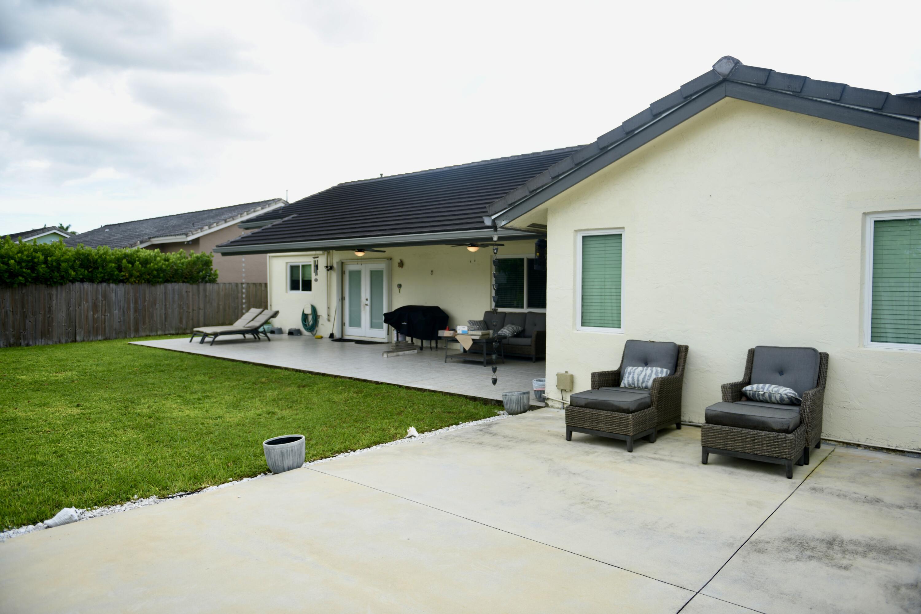 14931 Southwest 168th Court Miami, FL 33187 - Photo 20 of 34 a view of a patio with couches and a table and chairs with wooden fence