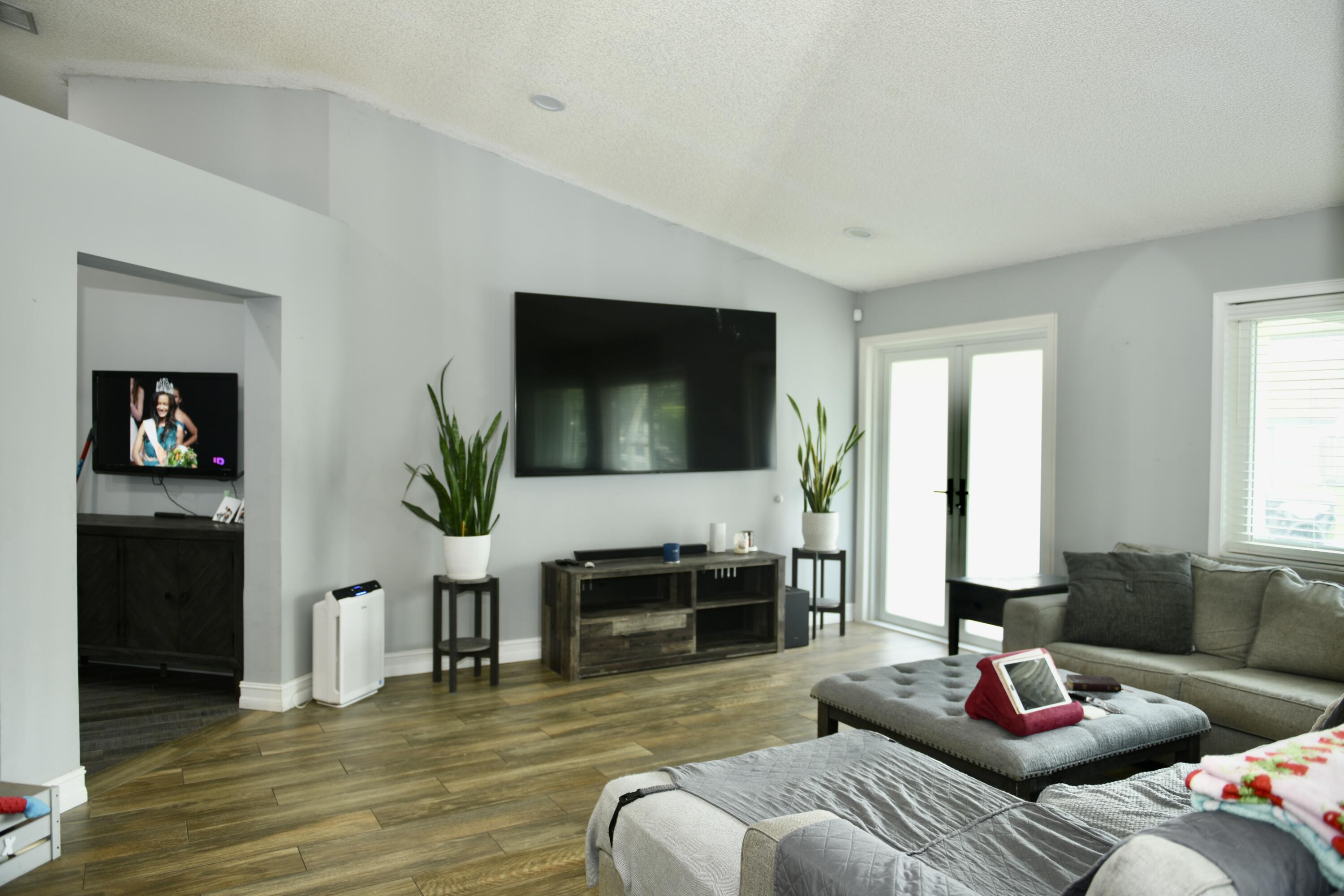 14931 Southwest 168th Court Miami, FL 33187 - Photo 2 of 34 a living room with furniture flat screen tv and a fireplace
