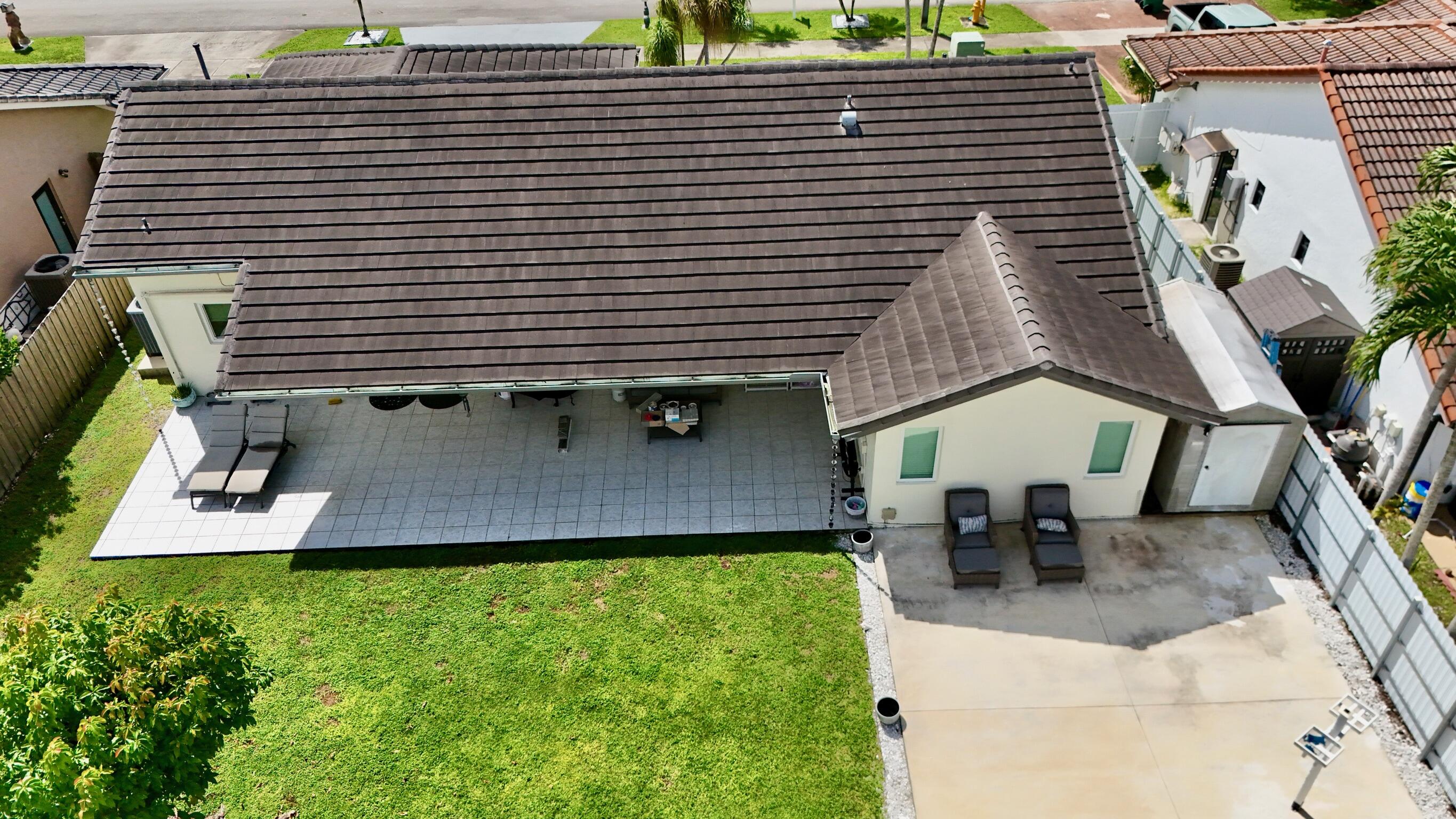 14931 Southwest 168th Court Miami, FL 33187 - Photo 30 of 34 a view of a patio with table and chairs potted plants and large tree