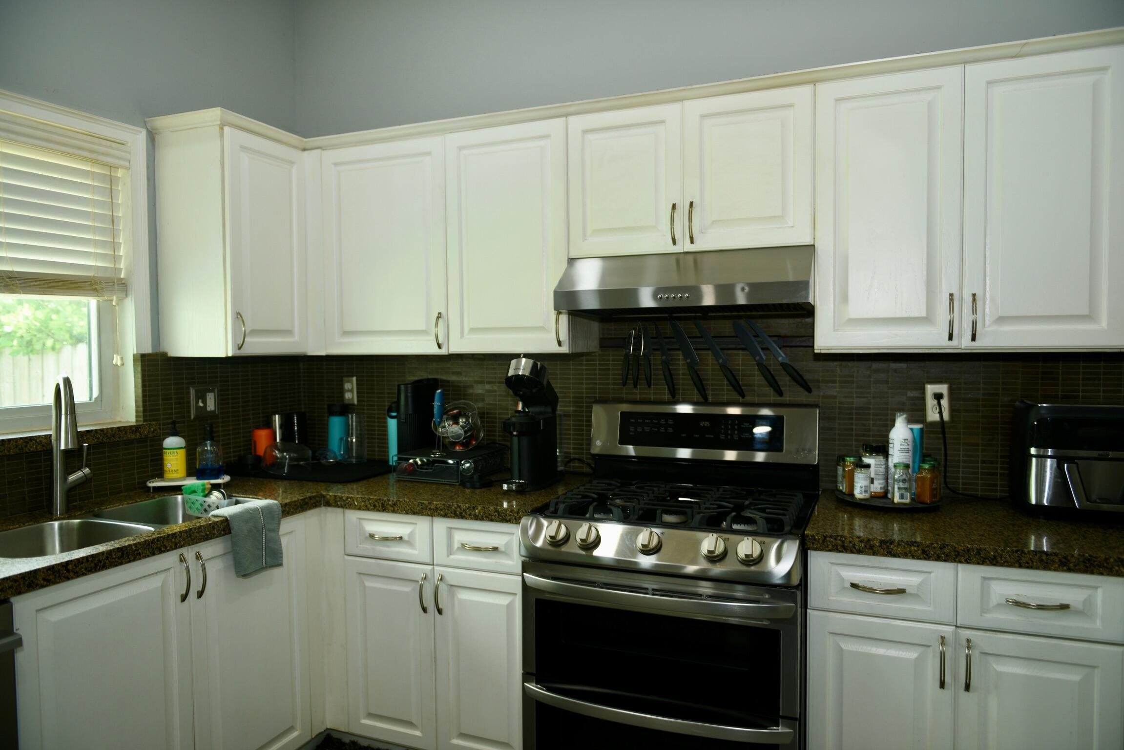 14931 Southwest 168th Court Miami, FL 33187 - Photo 3 of 34 a kitchen with a stove and white cabinets