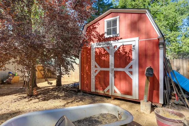a view of a house with a yard and large tree