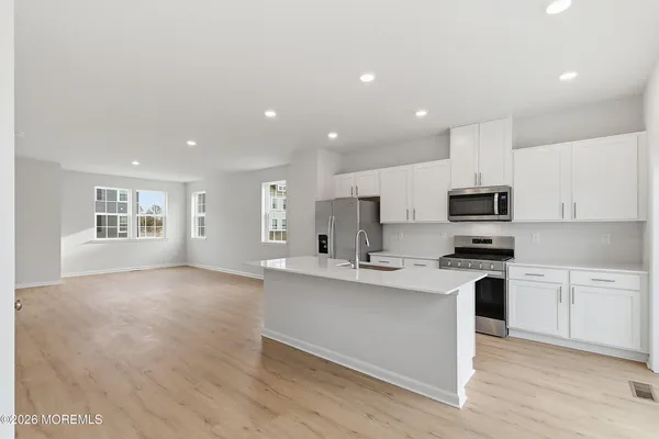 a kitchen with a sink cabinets and wooden floor