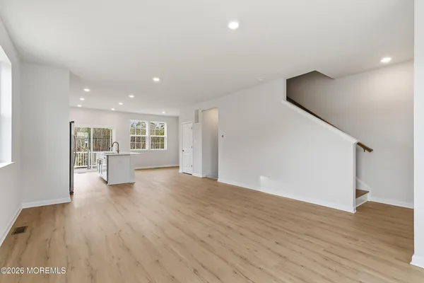 a kitchen with stainless steel appliances granite countertop a refrigerator a sink dishwasher a stove and a refrigerator with wooden floor