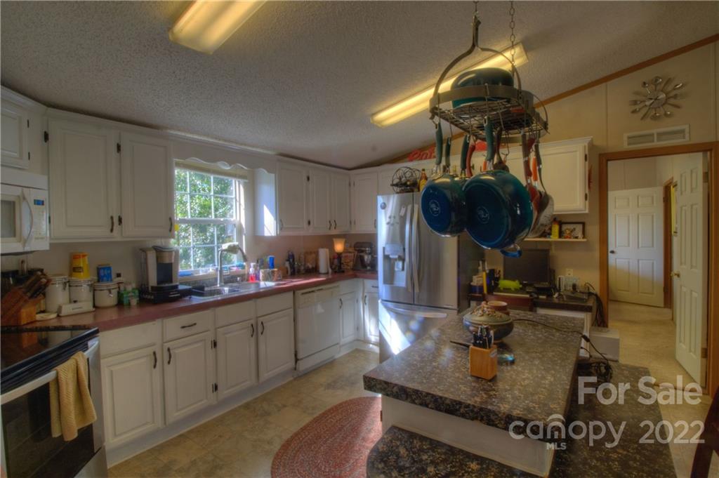 251 Rustic Ridge Drive Canton, NC 28716 - Photo 13 of 32 a kitchen with sink a stove and cabinets