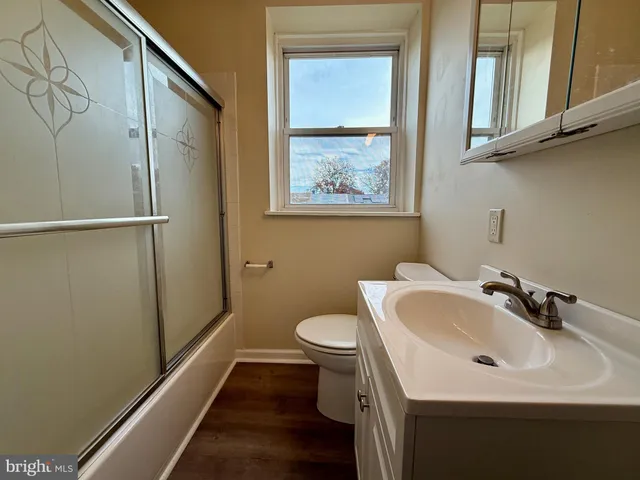 a bathroom with a sink and mirror with toilet