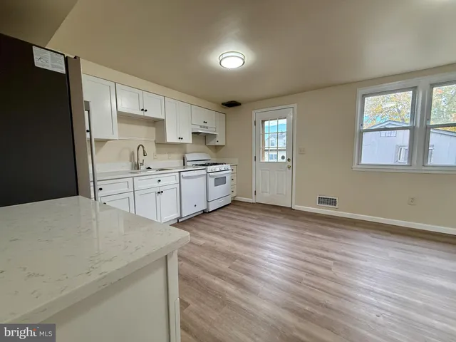 a kitchen with stainless steel appliances a sink cabinets and wooden floor