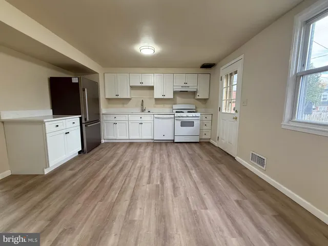 a open kitchen with cabinets stainless steel appliances a sink and a window