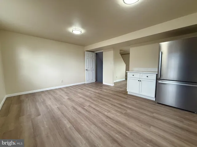 a view of empty room with wooden floor and window