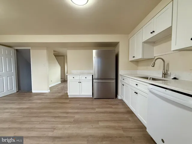 a kitchen with granite countertop a refrigerator and a sink