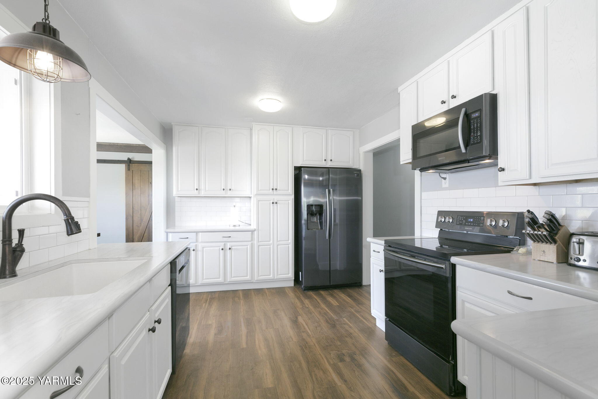 910 Gromore Road Yakima, WA 98908 - Photo 5 of 32 a kitchen with a sink white cabinets and stainless steel appliances