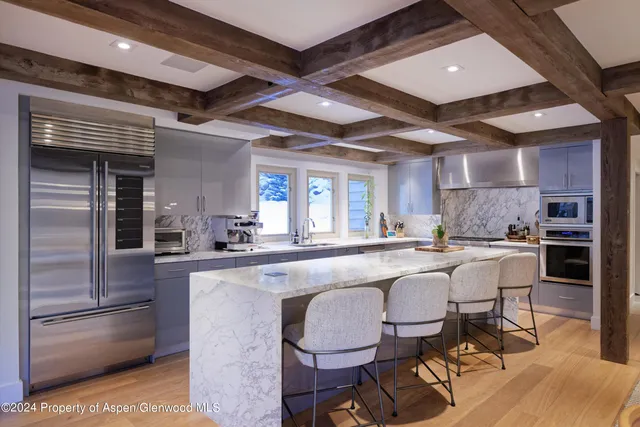 a large white kitchen with a table and chairs