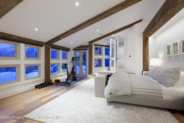 a bedroom with bed and a large window