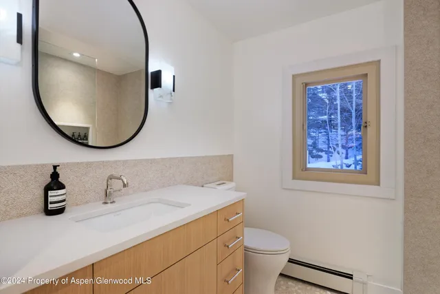 a bathroom with a toilet sink and mirror