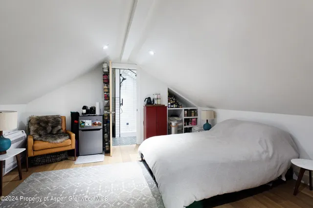 a bedroom with a bed couch and piano