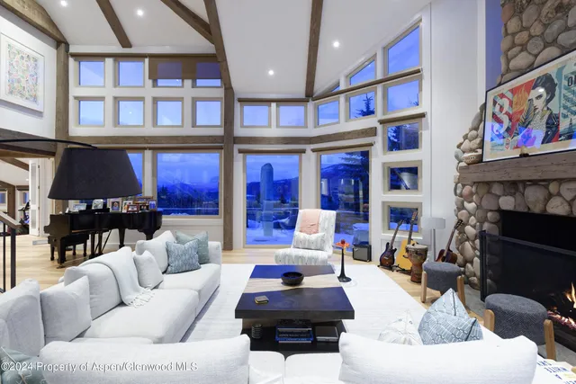 a living room with furniture a fireplace and a large window