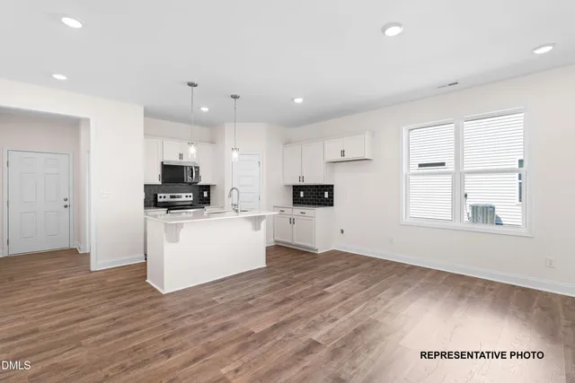 a view of kitchen with wooden floor and electronic appliances