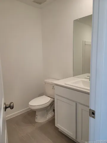 a bathroom with a granite countertop toilet and a sink