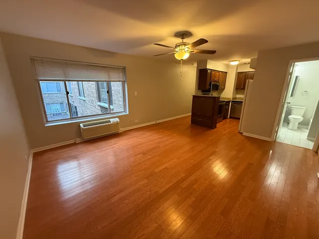 a view of a livingroom with wooden floor and a ceiling fan