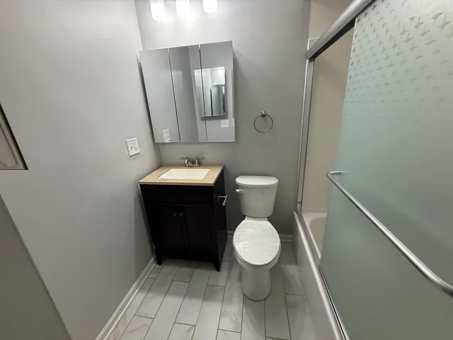 a bathroom with a toilet sink and mirror