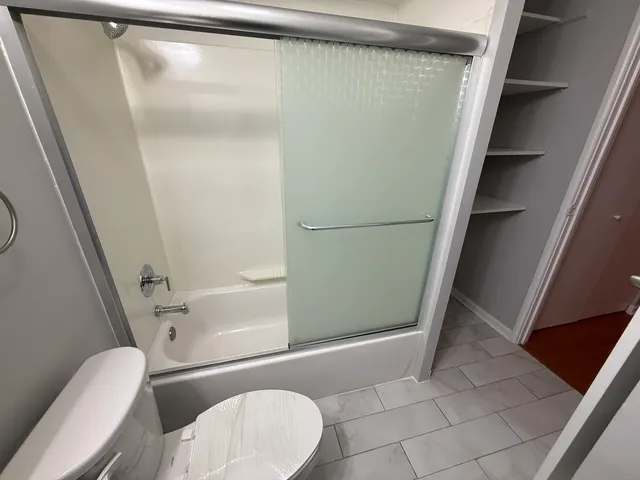a bathroom with a granite countertop shower and a toilet