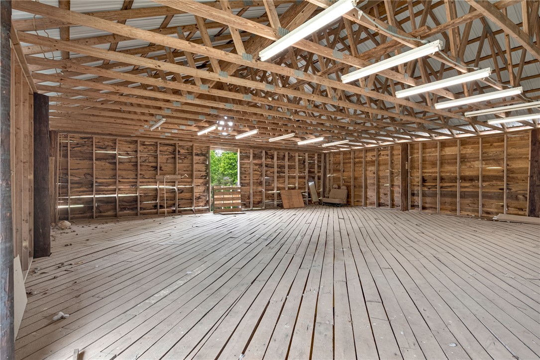 433 Latham Road Easley, SC 29640 - Photo 9 of 50 A spacious, unfinished interior with robust wood framing and plank flooring awaits your custom design.