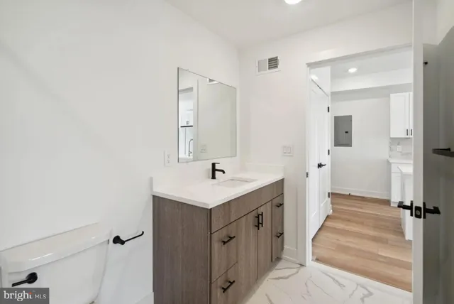 a bathroom with a sink a toilet and a mirror