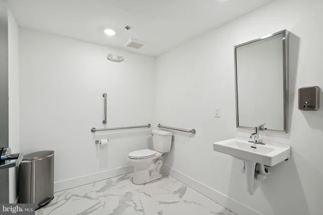 a bathroom with a sink toilet and mirror