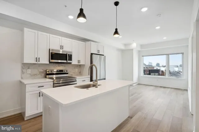 a kitchen with stainless steel appliances a stove a sink and a refrigerator