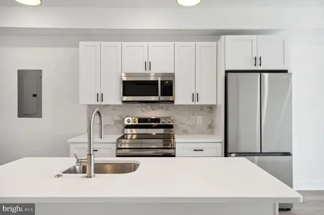 a kitchen with kitchen island a sink stainless steel appliances and cabinets
