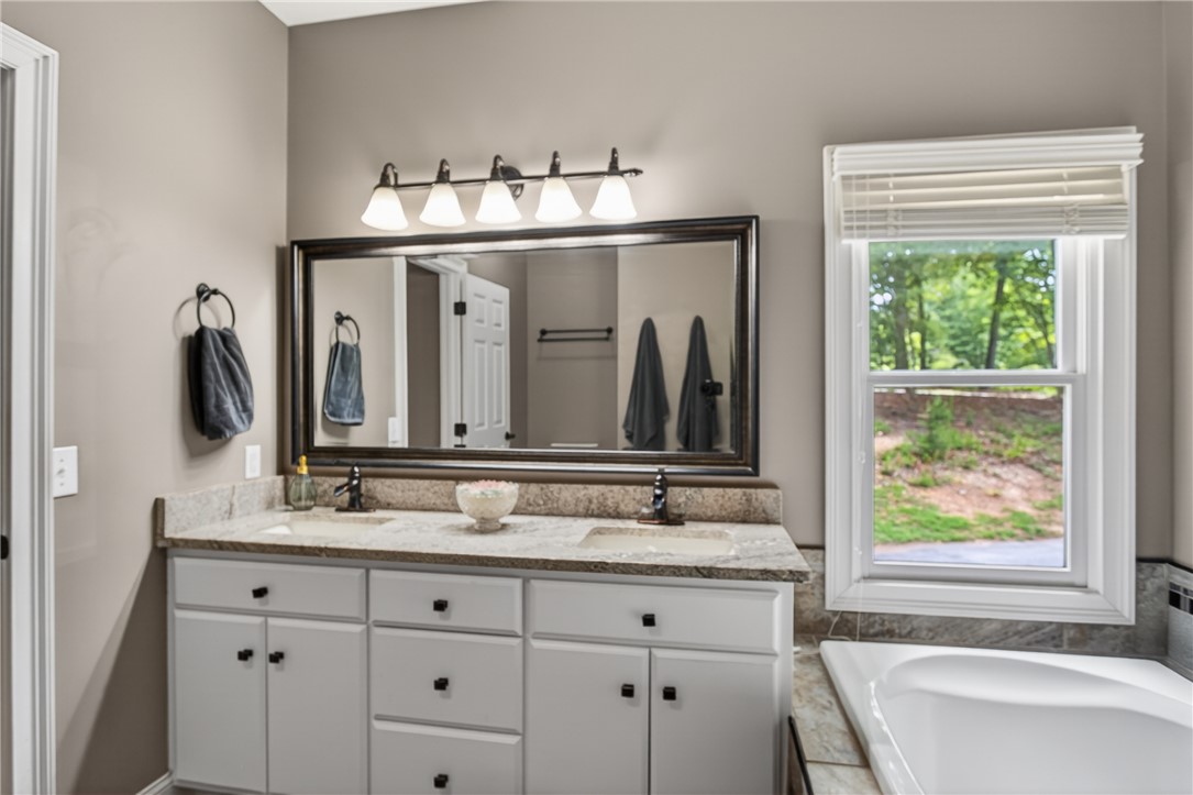136 Loran Pointe Circle Seneca, SC 29672 - Photo 19 of 50 Double vanity with stone counters and a spacious soaking tub creates a serene bathroom retreat.