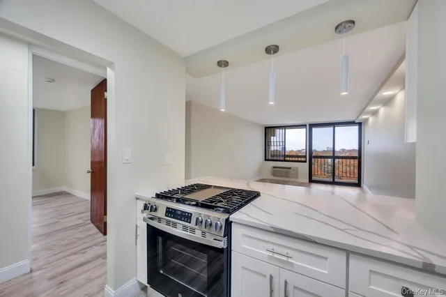 a kitchen with a stove and a wooden floor