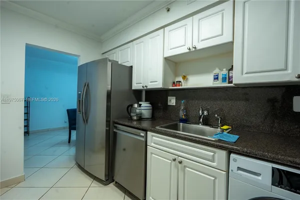 a kitchen with stainless steel appliances granite countertop a sink and a refrigerator