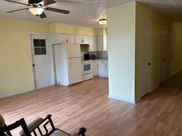 a kitchen with stainless steel appliances kitchen island a refrigerator sink and white cabinets