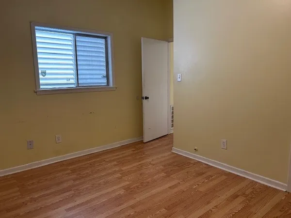 an empty room with wooden floor and a window