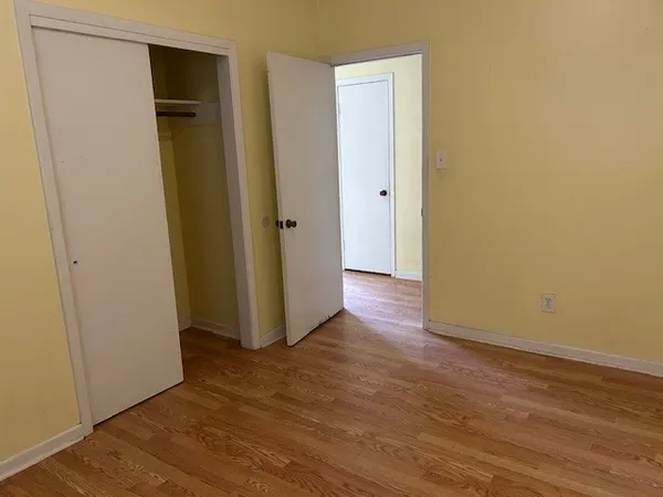 an empty room with wooden floor and closet