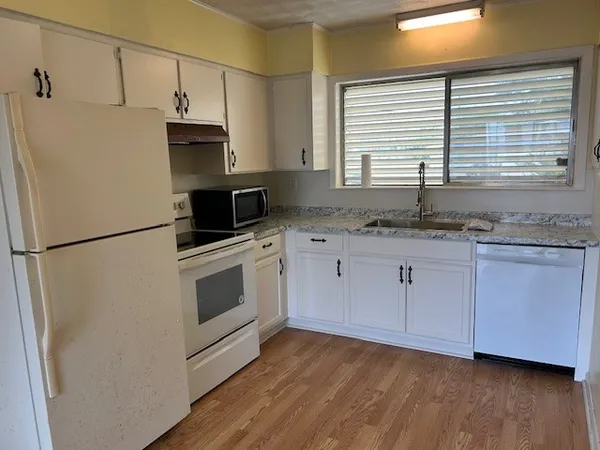 a kitchen with stainless steel appliances granite countertop a sink a stove a refrigerator and microwave