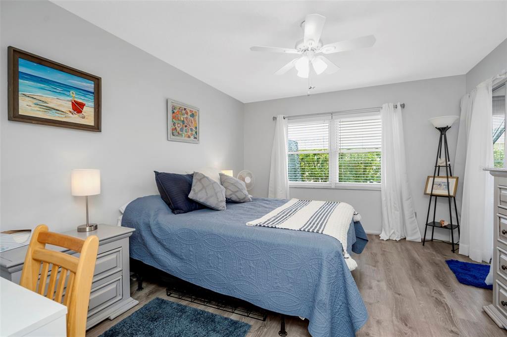 9617 Brassie Court New Port Richey, FL 34655 - Photo 18 of 41 a bedroom with a bed and a chandelier