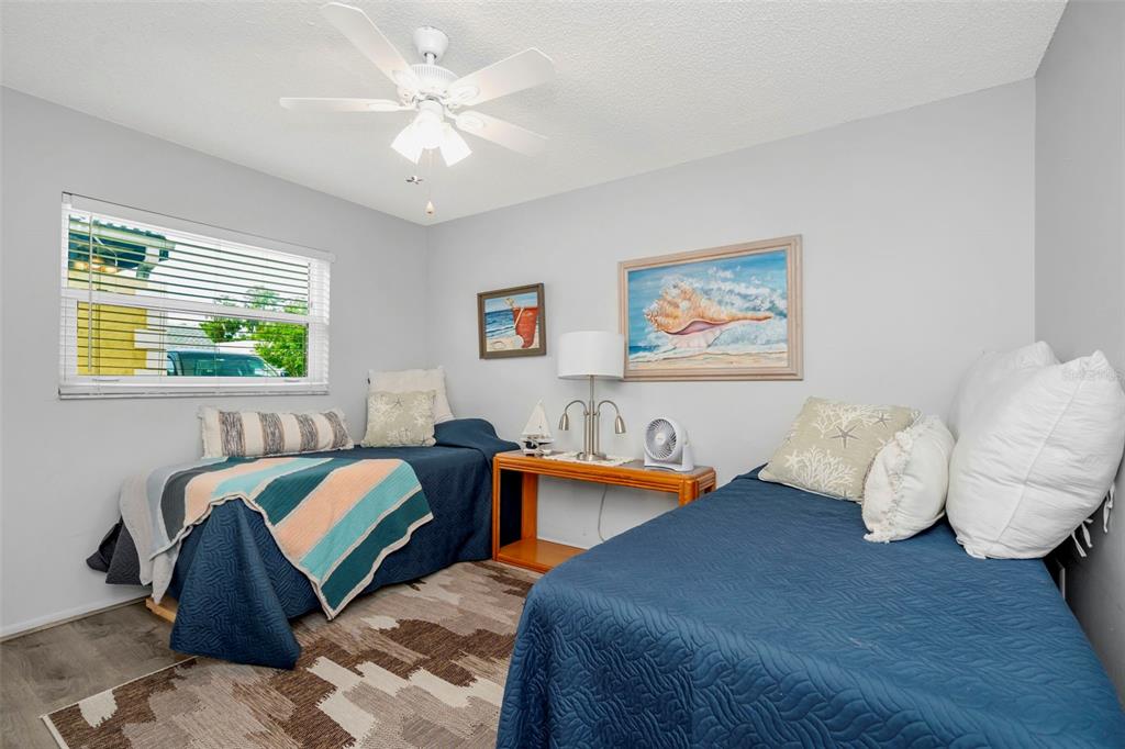 9617 Brassie Court New Port Richey, FL 34655 - Photo 24 of 41 a bedroom with two beds and a chandelier