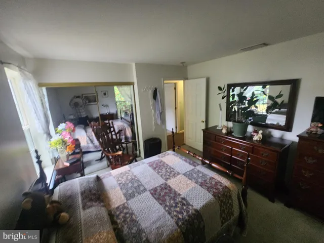 a bedroom with a bed and a flat tv screen on the dresser