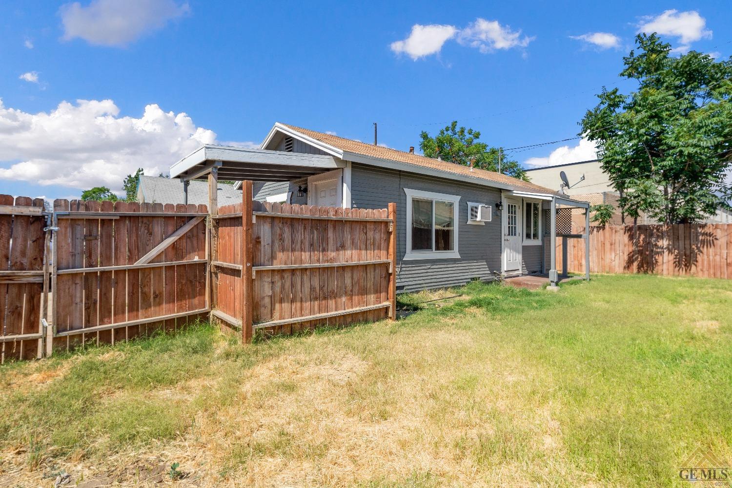 Undisclosed Address Bakersfield, CA 93308 - Photo 12 of 12 a view of a house with a yard and wooden fence